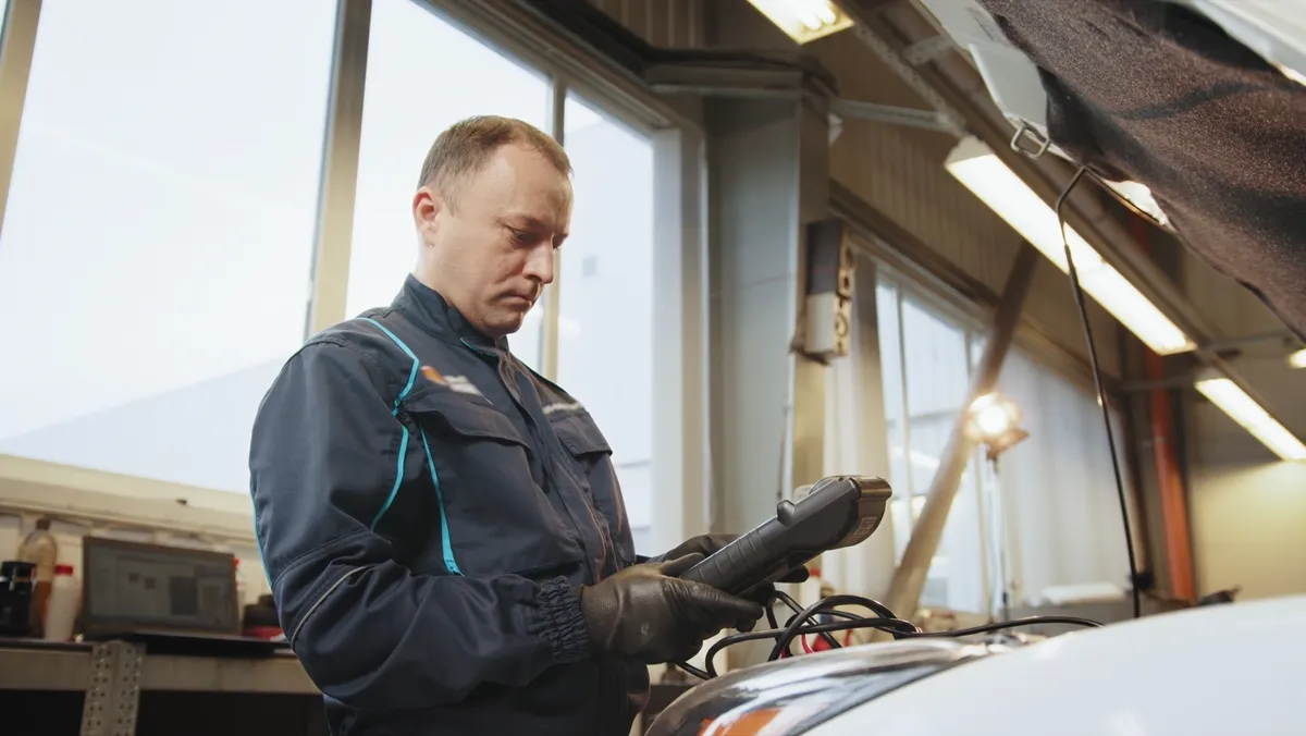 Illustrerende diagnose med nettbrett ved bil